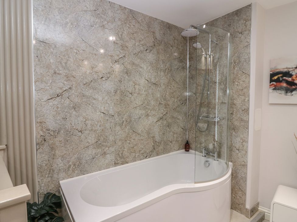 A bathroom with a bathtub and shower at 2 Abbey Row in Kelso