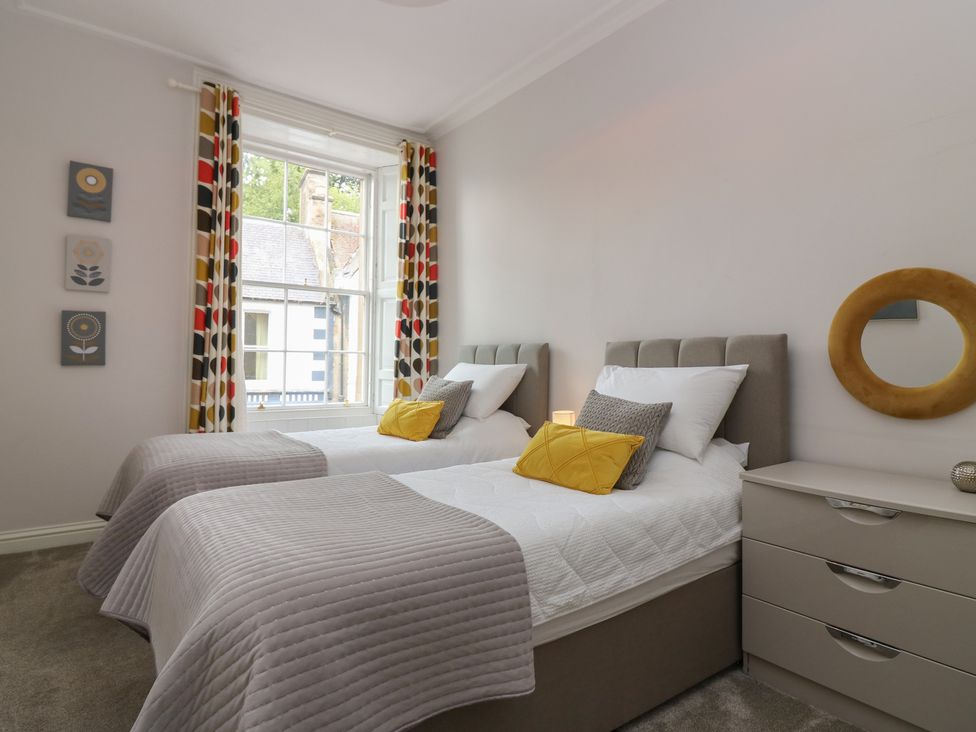 A bedroom with two single beds and a window at 2 Abbey Row in Kelso