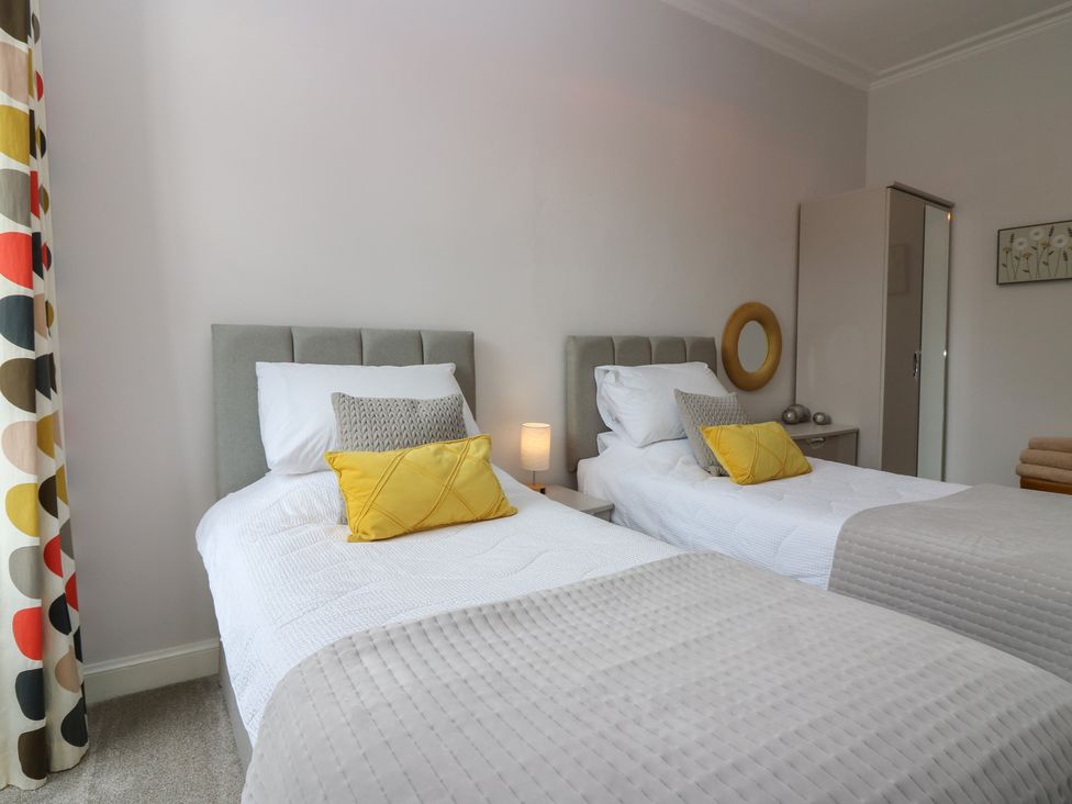 A bedroom with two beds and a wardrobe at 2 Abbey Row in Kelso