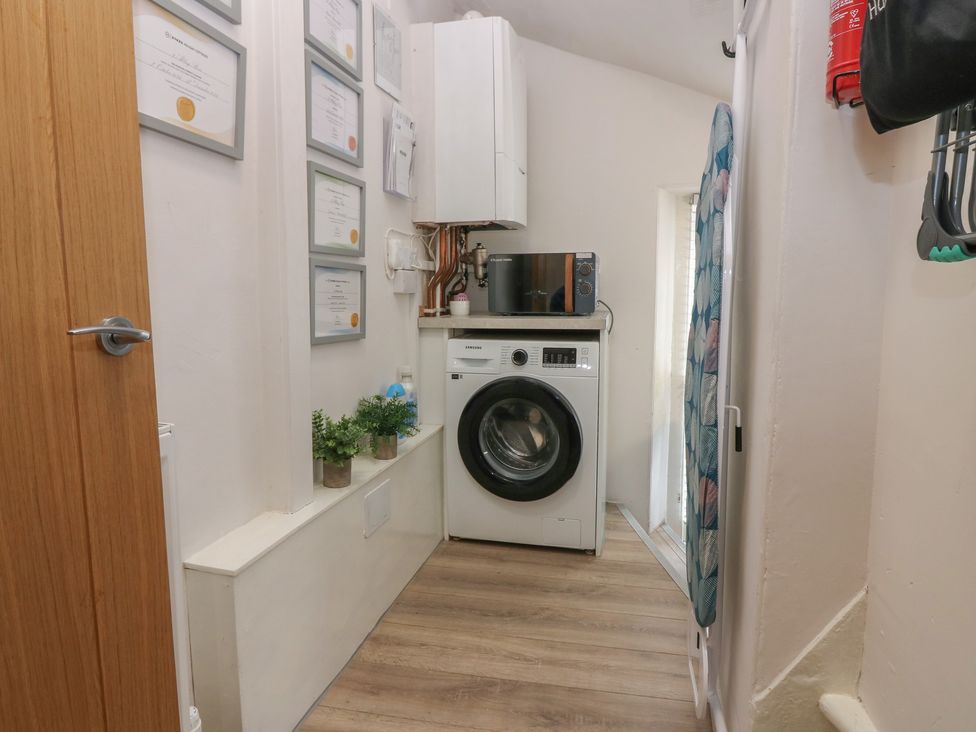 A laundry room with a washing machine and microwave at 2 Abbey Row in Kelso