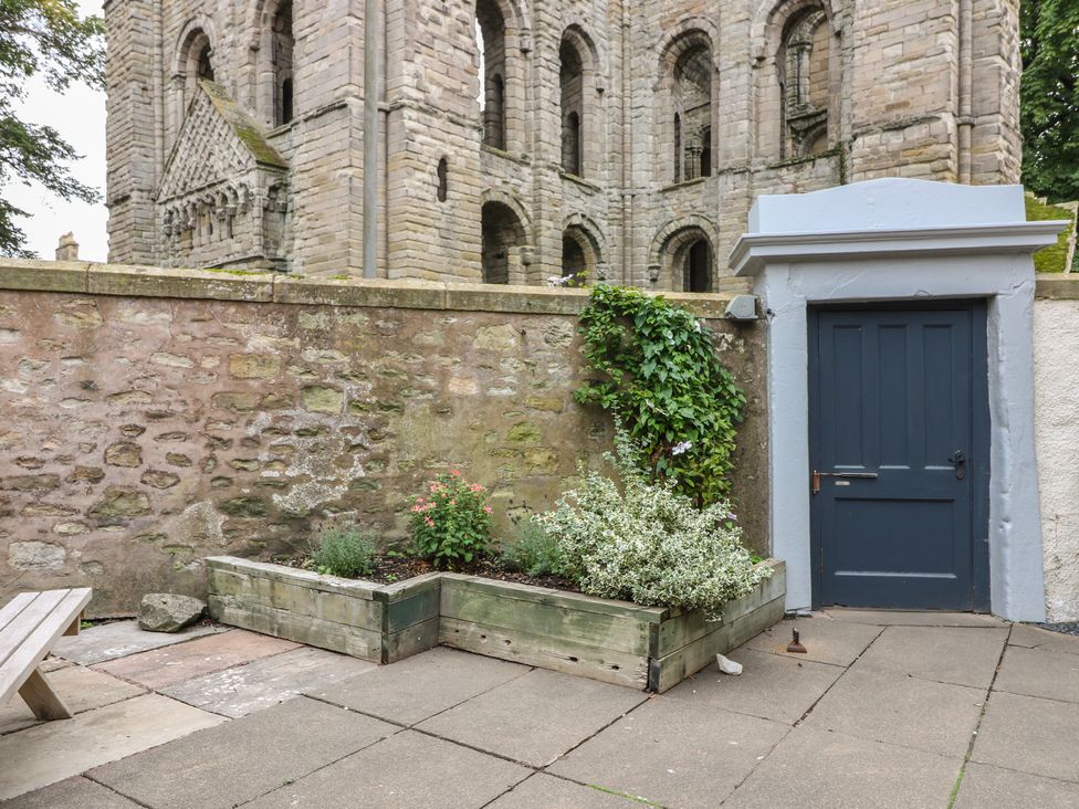 A garden area with a planter and a wall at 2 Abbey Row in Kelso