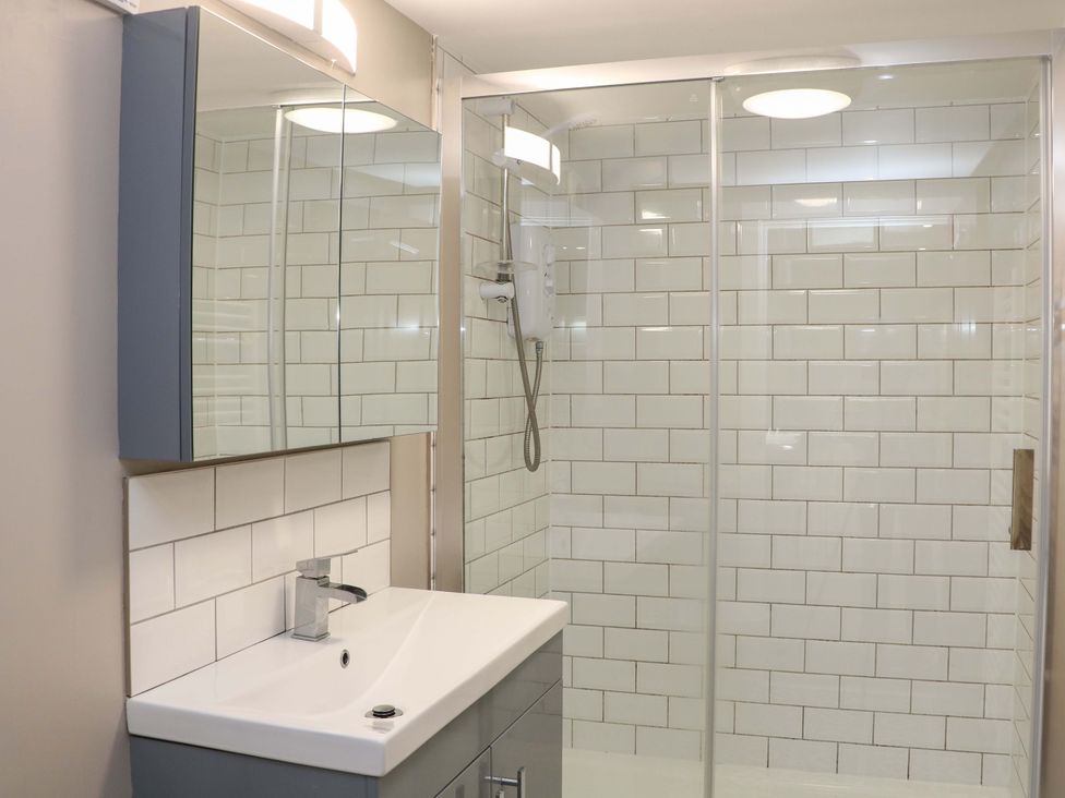 A bathroom with a shower and sink at Charlotte’s Cottage Hathersage
