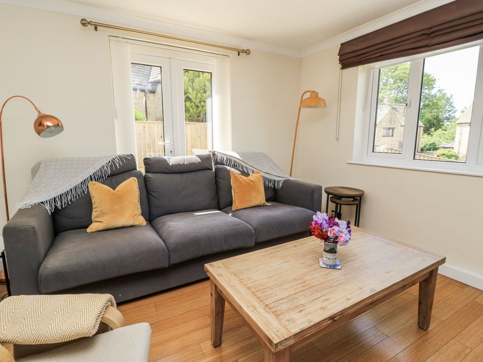 A living room with a sofa and wooden table at White Stones in Fulbrook, near Burford