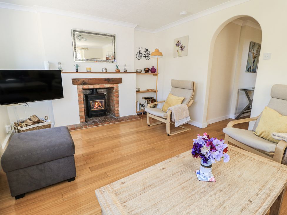 A living room with a fireplace and seating area at White Stones in Fulbrook, near Burford
