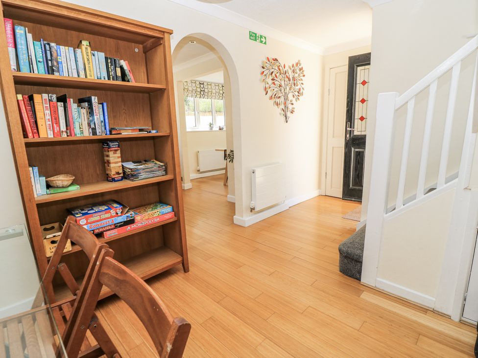 A hallway with a bookshelf and chair at White Stones Fulbrook, near Burford