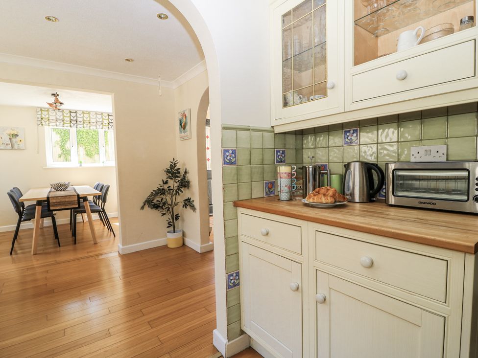 A kitchen with a table and chairs in the background at White Stones in Fulbrook, near Burford