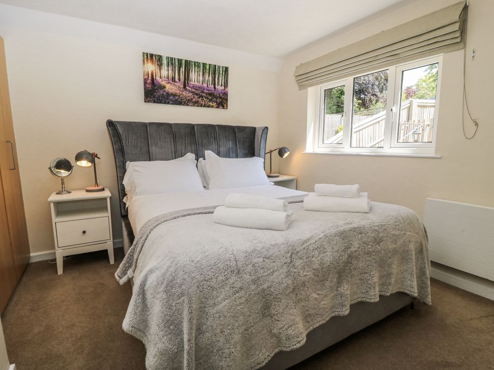 A bedroom with a double bed and a bedside table at White Stones, Fulbrook, near Burford