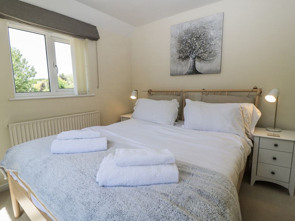 A bedroom with a bed and bedside table at White Stones in Fulbrook, near Burford