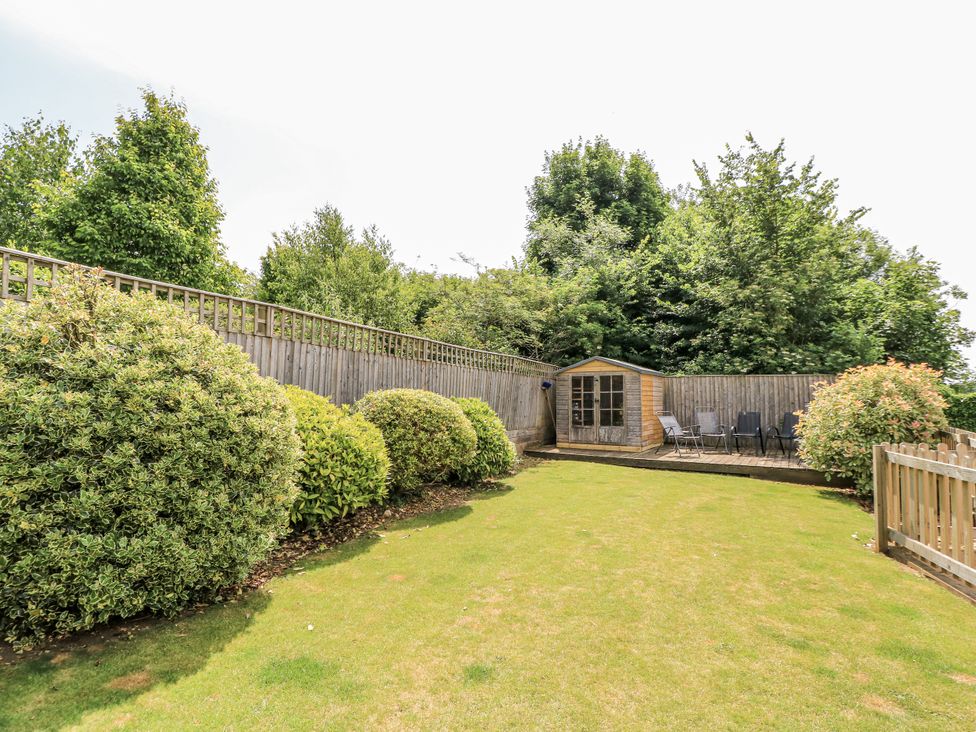 A garden with a shed and chairs at White Stones, Fulbrook, near Burford