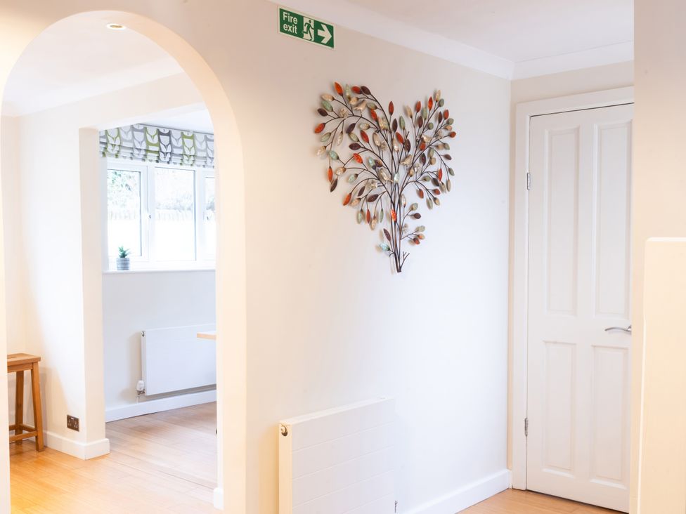 A hallway with wall art and an exit sign at White Stones Fulbrook, near Burford