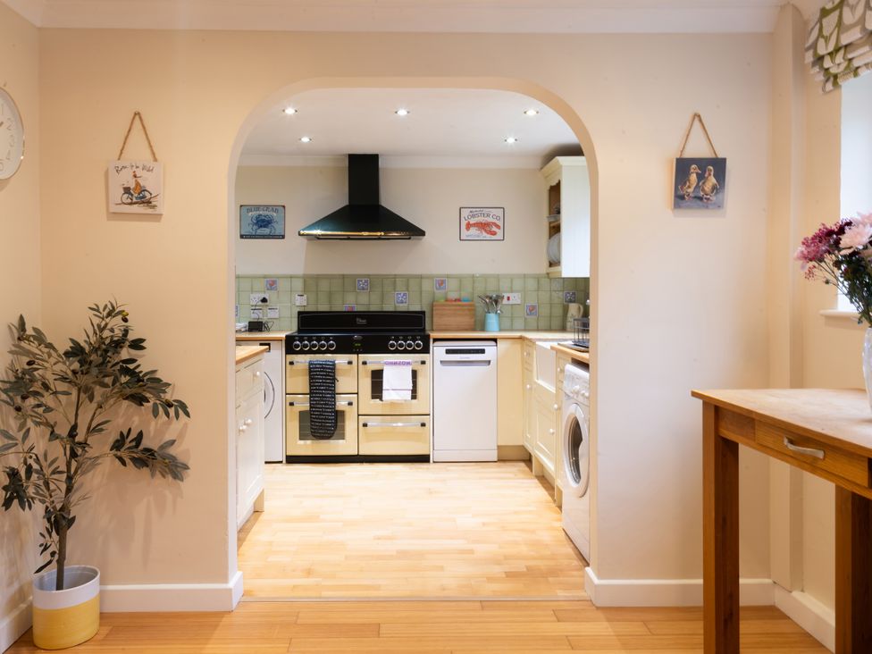 A kitchen with appliances and a table at White Stones in Fulbrook, near Burford