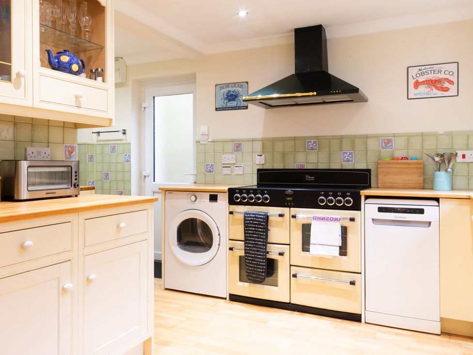 A kitchen with appliances including a microwave, oven, and washing machine at White Stones, Fulbrook, near Burford