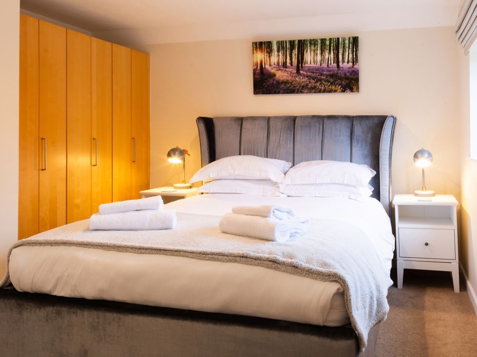A bedroom with a bed and wardrobe at White Stones Fulbrook, near Burford