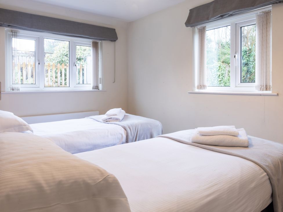 A bedroom with two beds and windows at White Stones in Fulbrook, near Burford