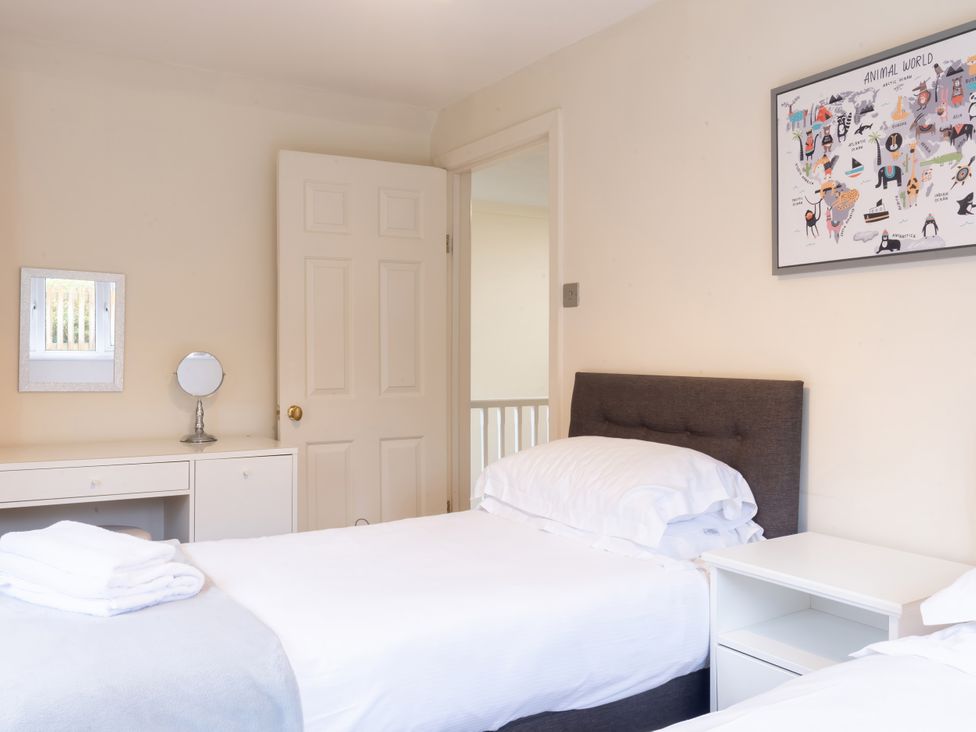A bedroom with twin beds and a mirror at White Stones Fulbrook, near Burford