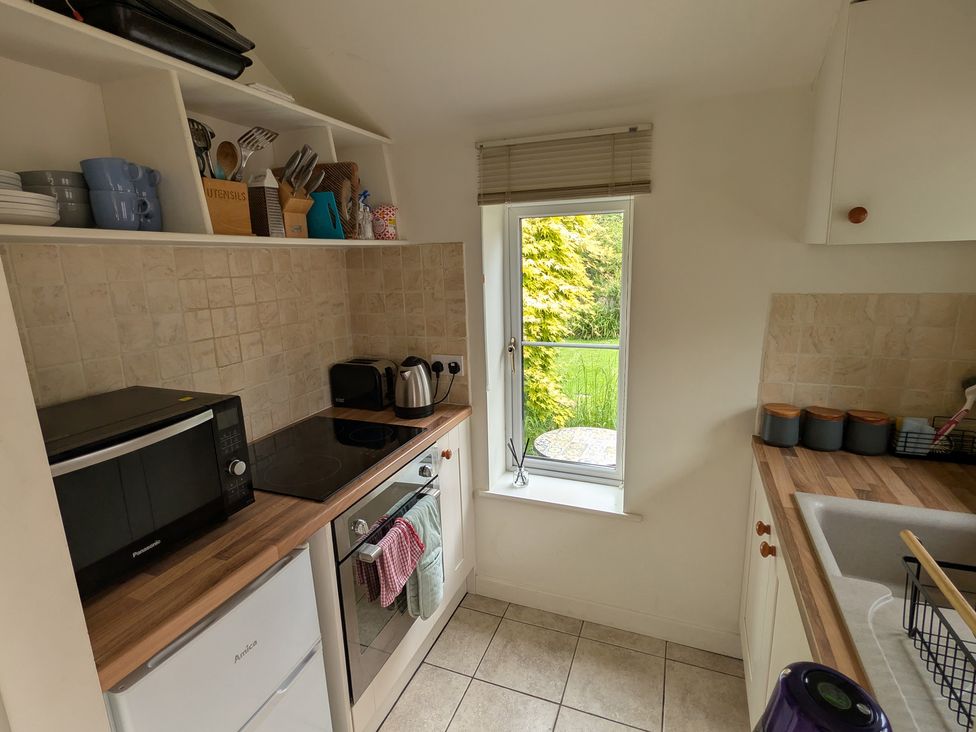 A kitchen with appliances and utensils at Little Pandy Cottage Afonwen near Caerwys