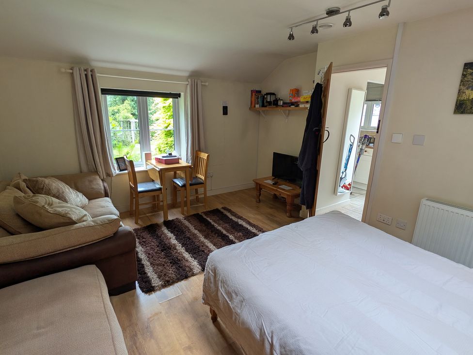 A studio apartment with a sofa and a dining area at Little Pandy Cottage Afonwen near Caerwys