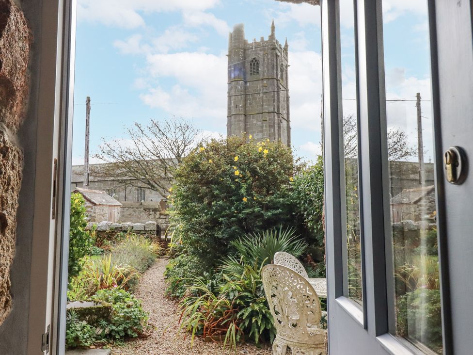 A view of a garden with a church tower in the background at 3 The Green