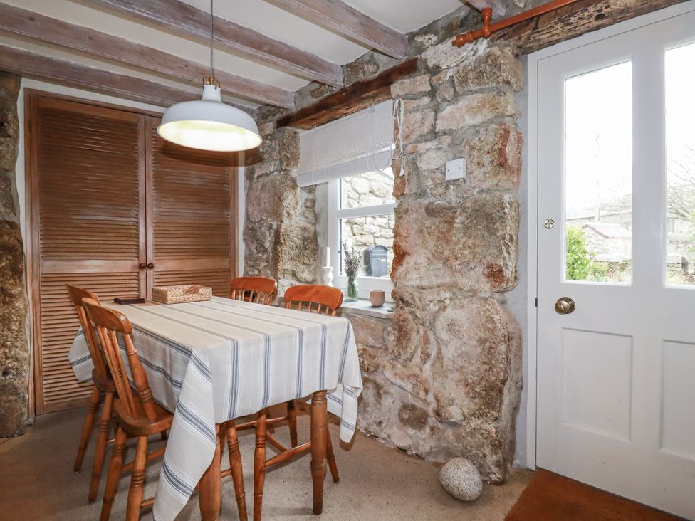 A dining room with a wooden table and chairs at 3 The Green