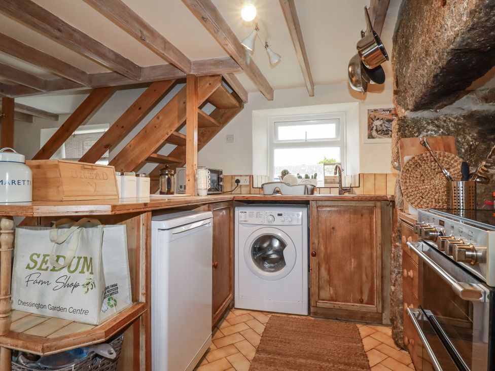 A kitchen with washing machine, stove, and sink at 3 The Green