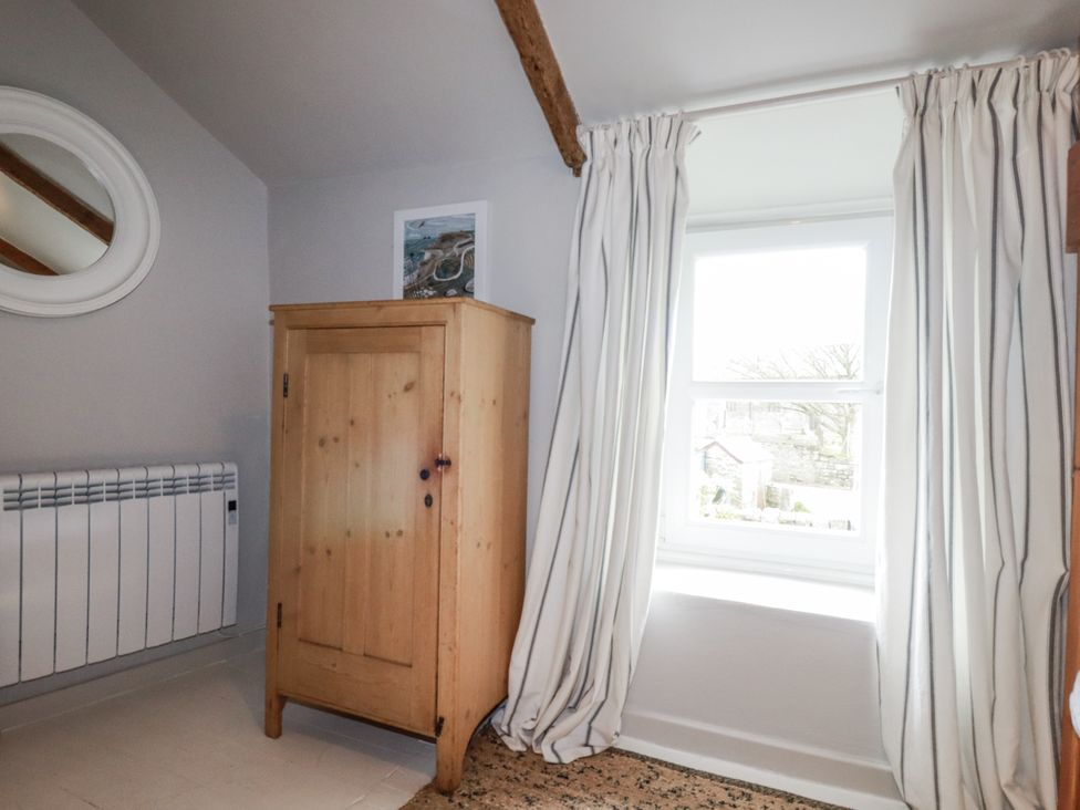 A bedroom with a wardrobe and window at 3 The Green