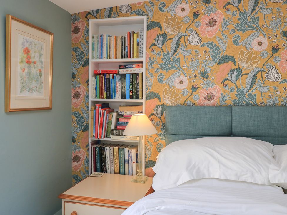 A bedroom with a bed and bookshelves at 4 Duck Street, Dorchester