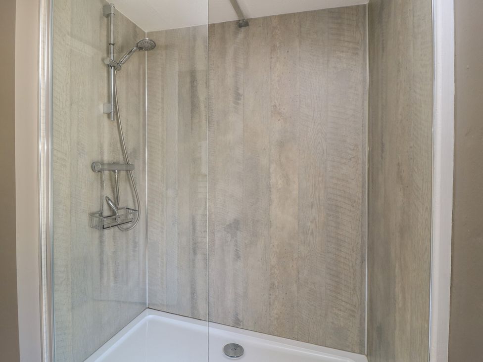 A shower enclosure with a glass door and tiled walls at 4 Duck Street Dorchester