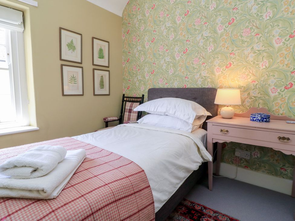 A bedroom with a bed and side table at 4 Duck Street in Dorchester