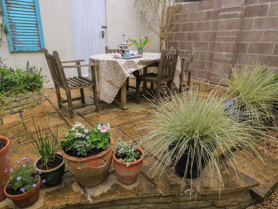 A garden with a table and chairs surrounded by plants at 4 Duck Street in Dorchester