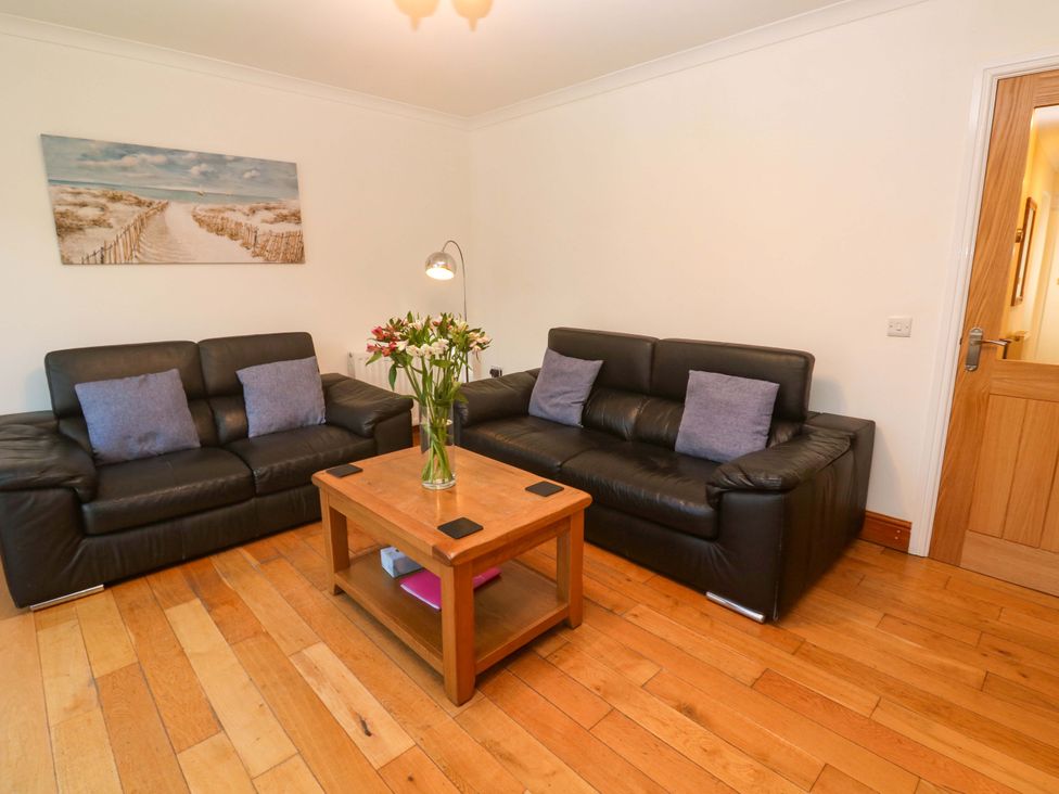 A living room with two sofas and a wooden coffee table at Cherry Tree House in Penzance