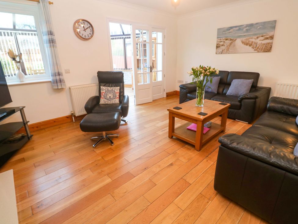 A living room with a clock and a coffee table at Cherry Tree House in Penzance