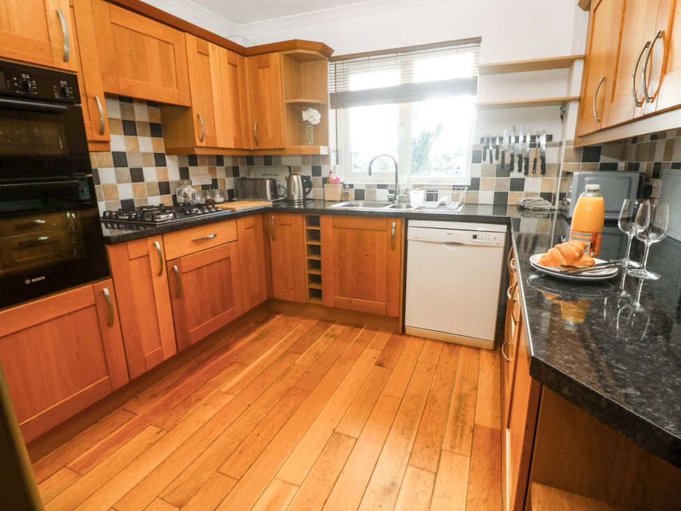 A kitchen with cabinets and appliances at Cherry Tree House in Penzance