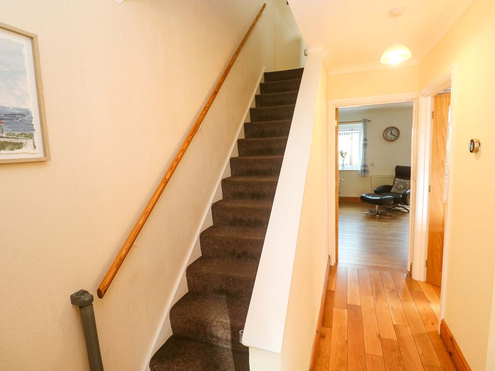 A hallway with a staircase and a door at Cherry Tree House in Penzance