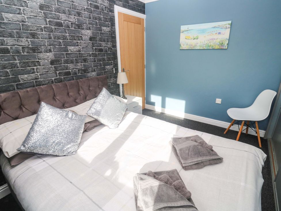 A bedroom with a bed and chair at Cherry Tree House in Penzance