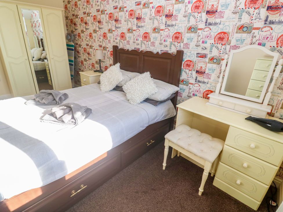 A bedroom with a bed and dressing table at Cherry Tree House in Penzance