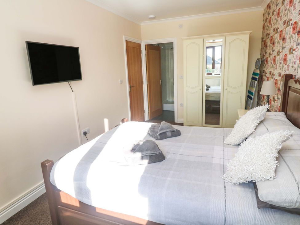 A bedroom with a bed and a tv at Cherry Tree House in Penzance