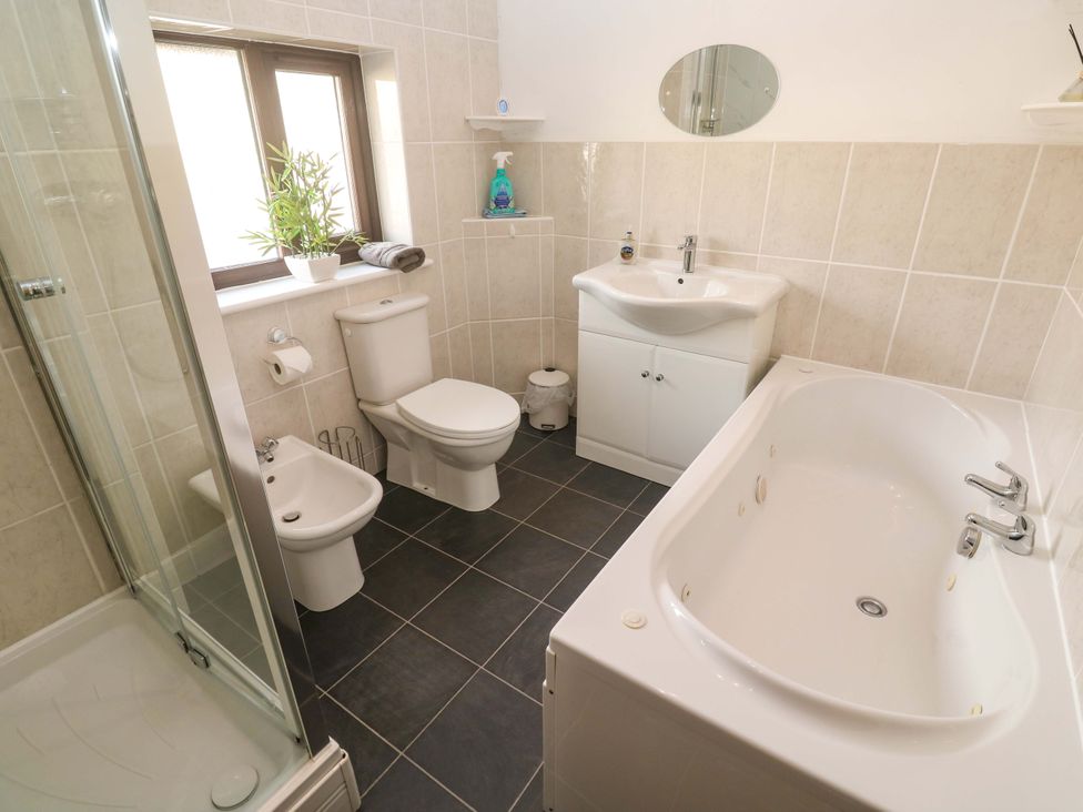 A bathroom with a bathtub, toilet, bidet, sink, and shower at Cherry Tree House in Penzance