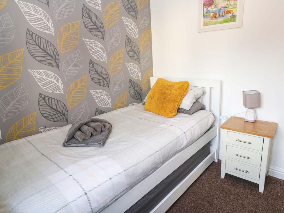A bedroom with a bed and nightstand at Cherry Tree House in Penzance