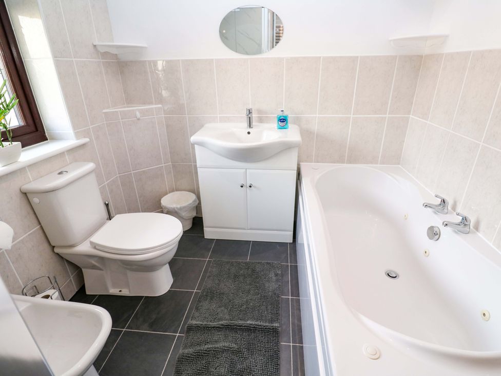 A bathroom with a sink, toilet and bathtub at Cherry Tree House in Penzance