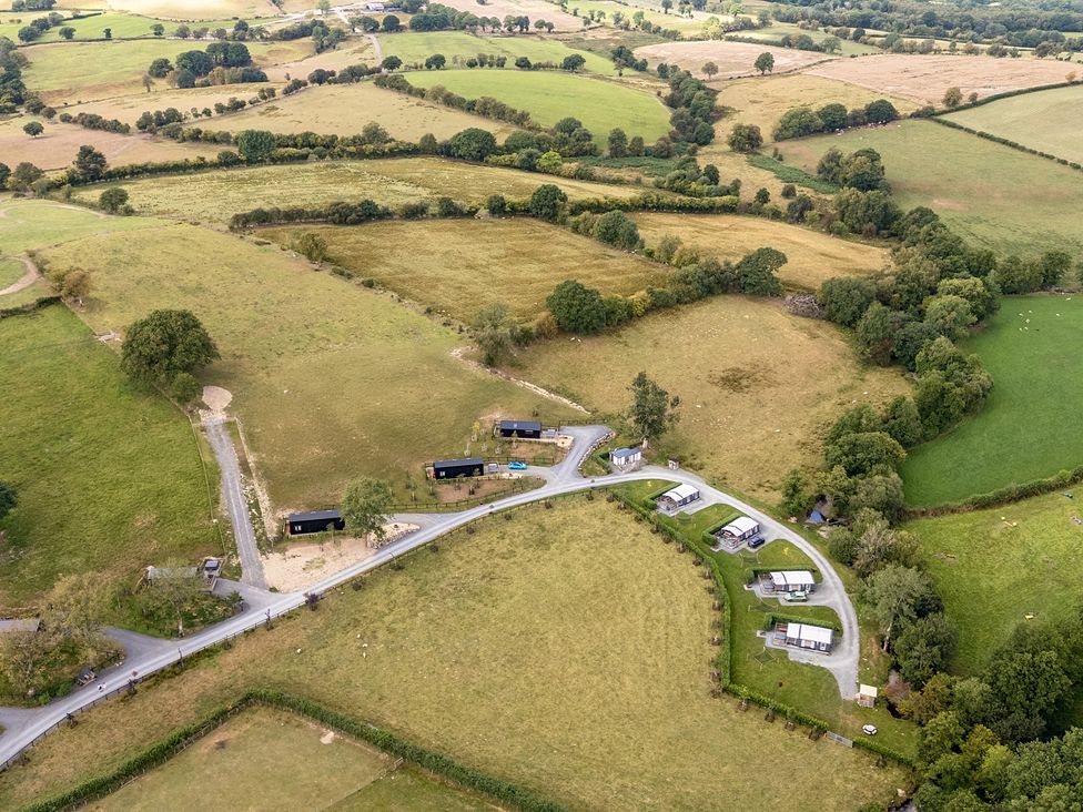 A view of fields and cabins in an outdoor setting at Oak Tree View Nantmel near Rhayader