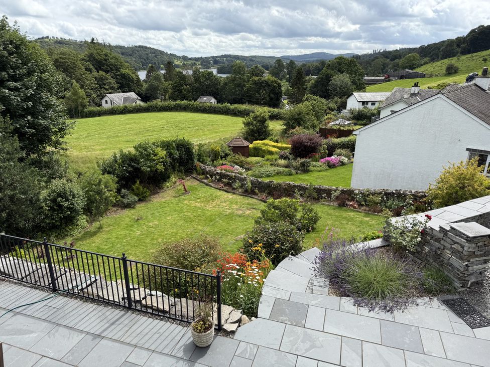 A garden with a stone patio and grass lawn at Estcote Roger Ground near Hawkshead