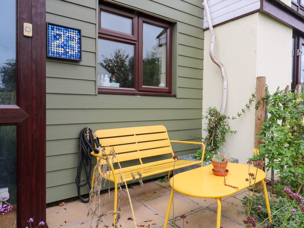 An outdoor area with a yellow bench and table at Coastguard Cottage in Rye