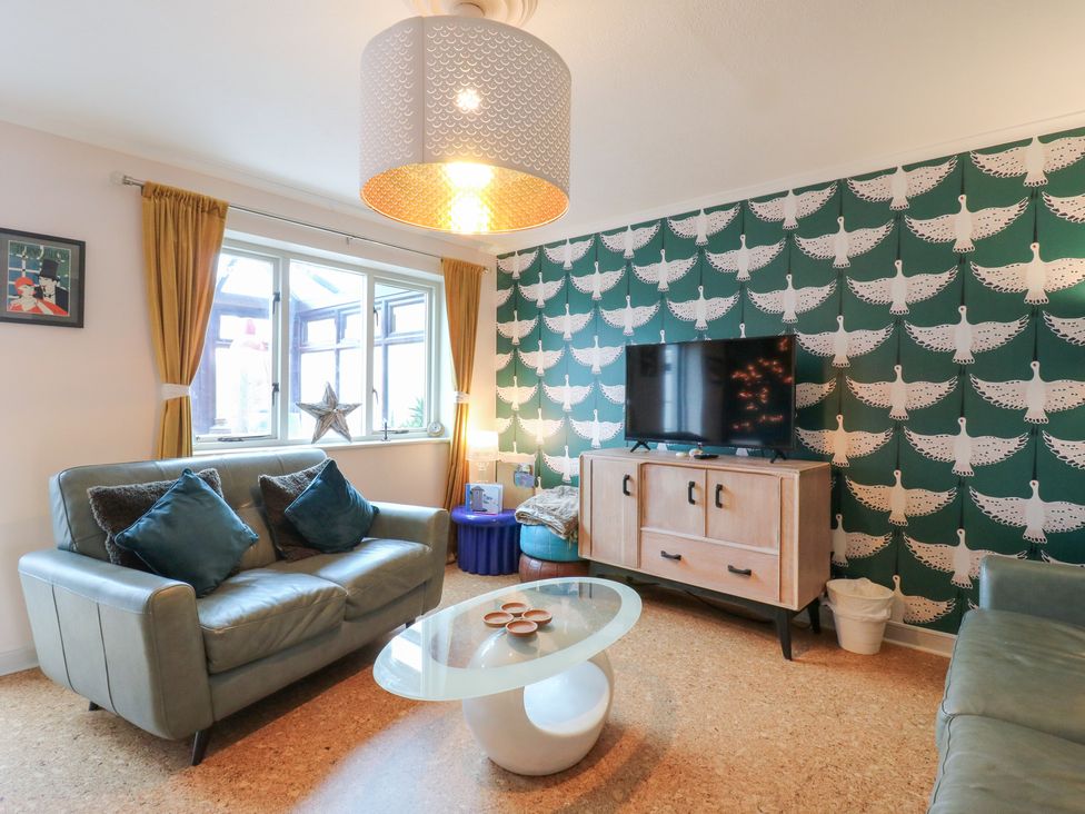 A living room with a television and sofas at Coastguard Cottage in Rye