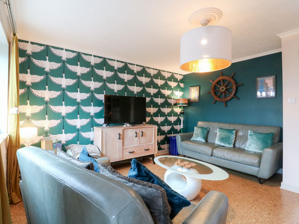 A living room with a sofa and television at Coastguard Cottage in Rye