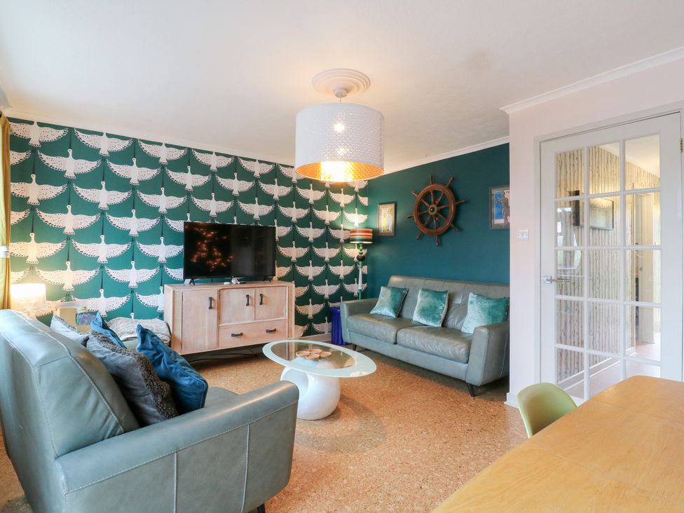 A living room with a TV and a coffee table at Coastguard Cottage in Rye