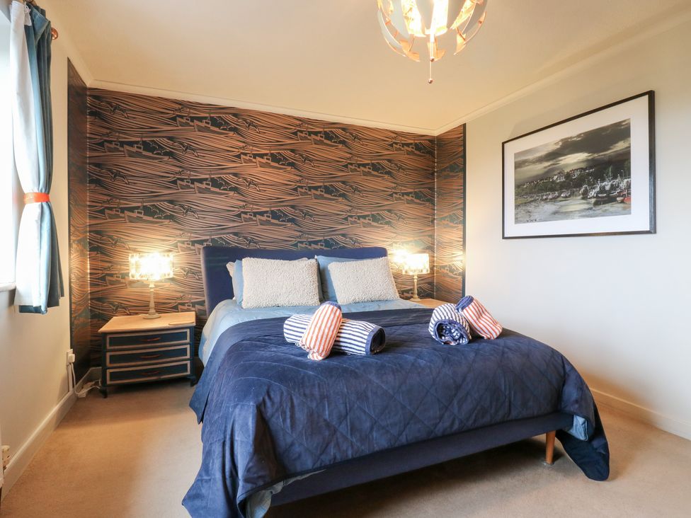 A bedroom with a bed and bedside table at Coastguard Cottage in Rye