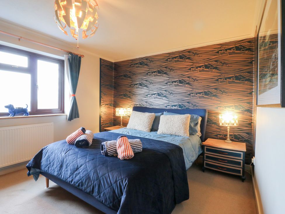 A bedroom with a bed and lamp at Coastguard Cottage in Rye