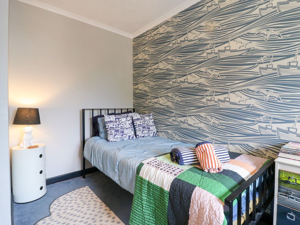 A bedroom with a bed, pillow, and lamp at Coastguard Cottage in Rye