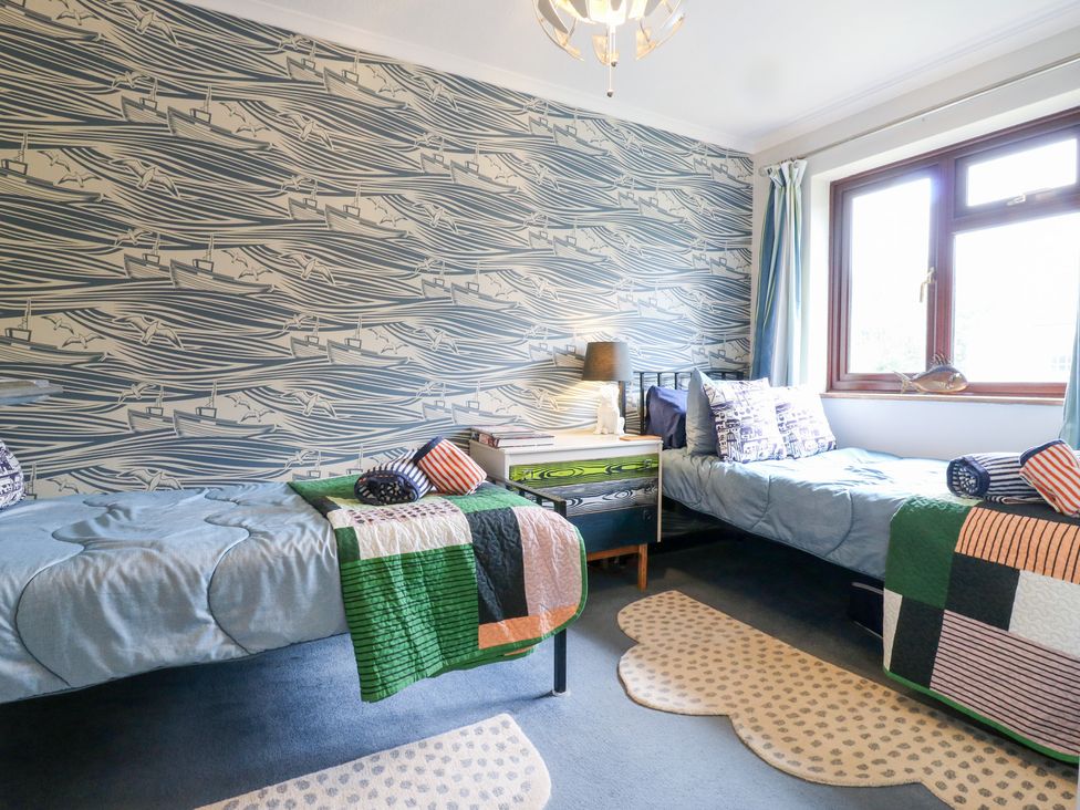 A bedroom with two beds and a window at Coastguard Cottage in Rye
