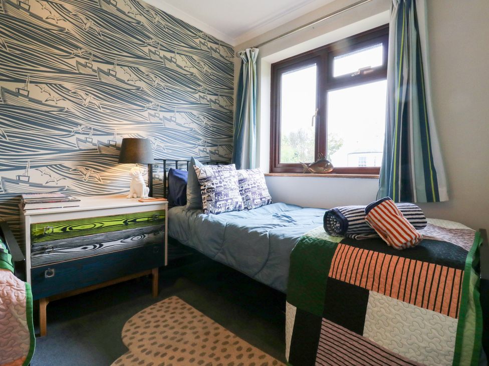 A bedroom with a bed and a window at Coastguard Cottage in Rye